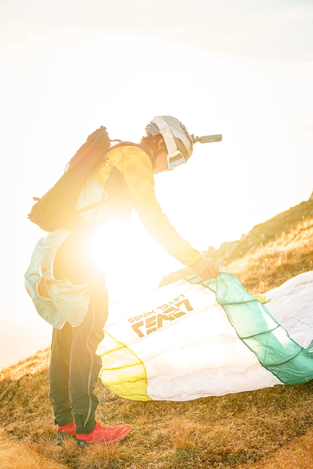 Envol en speedflying au coucher du soleil, silhouette à contre-jour